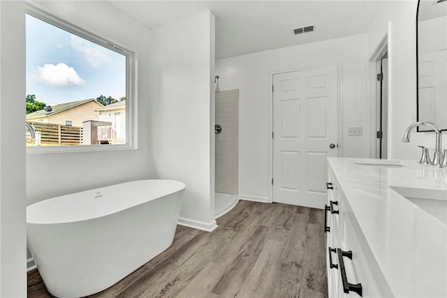 1938 Inman Dr, Anderson, SC 29625 - bathroom featuring double vanity, wood finished floors, a soaking tub, and a walk in shower