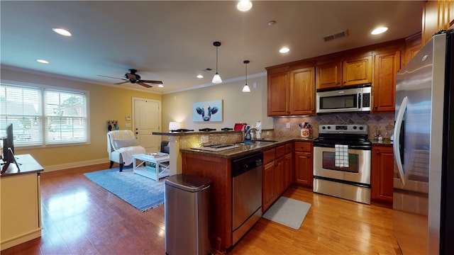 209 Calhoun St Unit 402, Clemson, SC 29631 - kitchen featuring appliances with stainless steel finishes, a peninsula, brown cabinets, crown molding, and tasteful backsplash