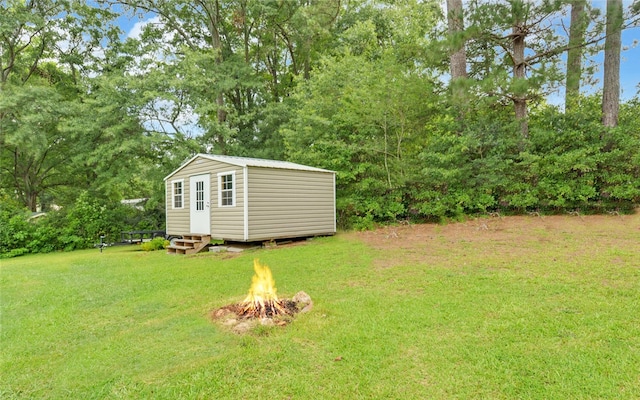 37 Cunningham Dr, Hartwell, GA 30643 - view of green lawn with a fire pit, an outdoor structure, and view of scattered trees