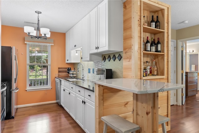 318 Weeping Willow Dr, Seneca, SC 29672 - kitchen with wood finished floors, white cabinets, a textured ceiling, decorative backsplash, and a chandelier