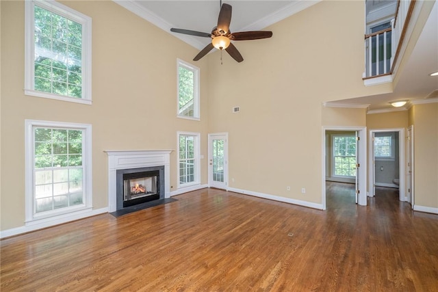 124 Bluestone Ct, Easley, SC 29642 - unfurnished living room with ornamental molding, wood finished floors, a high ceiling, ceiling fan, and a fireplace with flush hearth