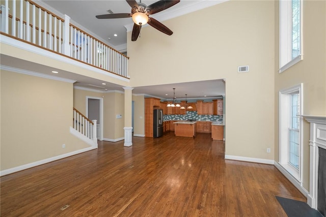 124 Bluestone Ct, Easley, SC 29642 - unfurnished living room with a high ceiling, a fireplace with flush hearth, a chandelier, a ceiling fan, and dark wood finished floors