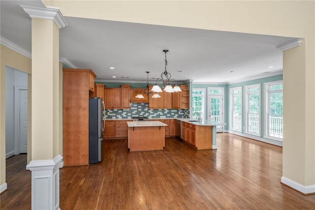 124 Bluestone Ct, Easley, SC 29642 - kitchen featuring appliances with stainless steel finishes, crown molding, light countertops, a kitchen island, and ornate columns