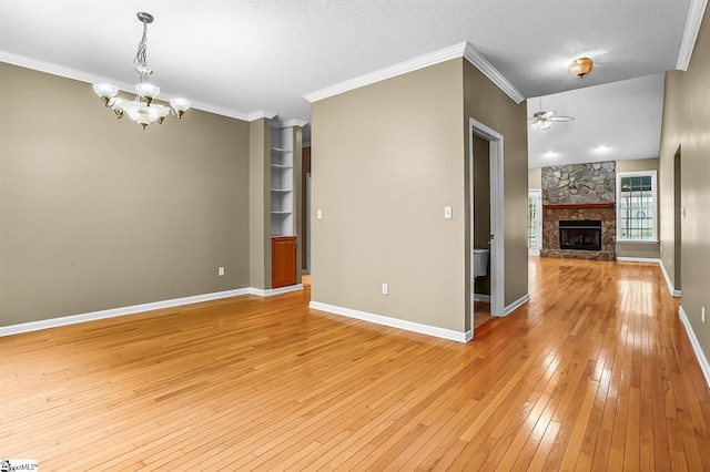 1298 Moorehead Pl, Pendleton, SC 29670 - unfurnished living room with light wood-style floors, a stone fireplace, a chandelier, ornamental molding, and ceiling fan