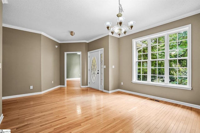1298 Moorehead Pl, Pendleton, SC 29670 - unfurnished room featuring light wood-style floors, a chandelier, crown molding, and a textured ceiling