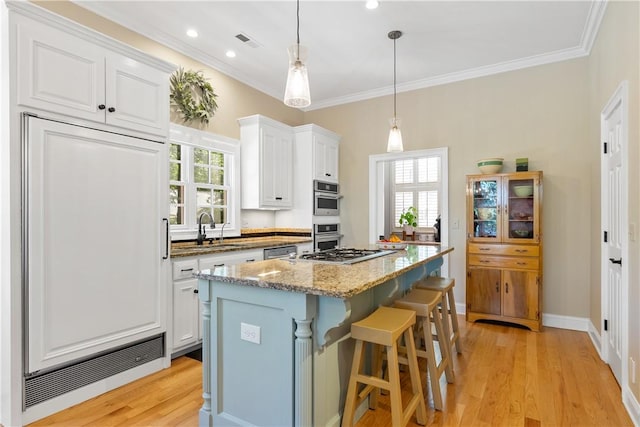 218 Royal Oaks Dr, Anderson, SC 29625 - kitchen featuring white cabinets, a kitchen island, appliances with stainless steel finishes, light stone countertops, and crown molding