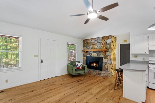 275 Lakeside Dr, Mountain Rest, SC 29664 - living area with lofted ceiling, light wood finished floors, a stone fireplace, and ceiling fan