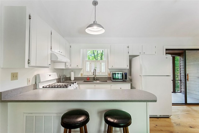 275 Lakeside Dr, Mountain Rest, SC 29664 - kitchen featuring white appliances, under cabinet range hood, a peninsula, white cabinetry, and light wood finished floors