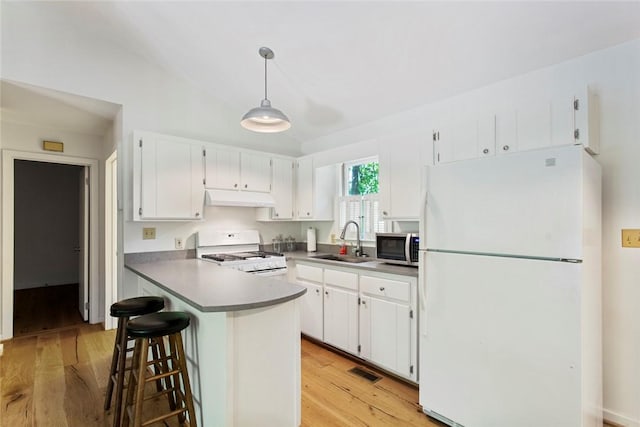 275 Lakeside Dr, Mountain Rest, SC 29664 - kitchen with white appliances, under cabinet range hood, light wood-style flooring, white cabinetry, and lofted ceiling