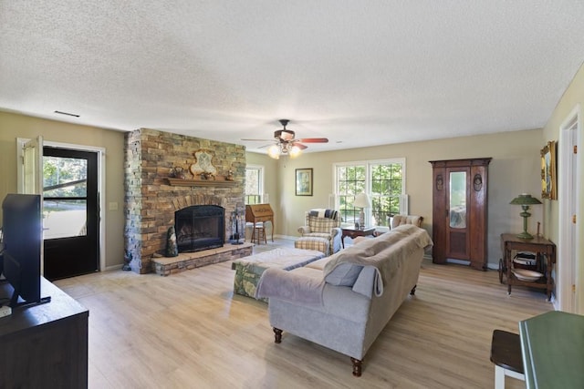118 Nonna Ln, Seneca, SC 29678 - living area featuring a textured ceiling, light wood finished floors, a fireplace, and a ceiling fan