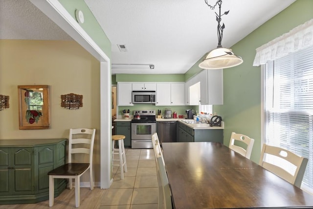 118 Nonna Ln, Seneca, SC 29678 - kitchen featuring appliances with stainless steel finishes, white cabinetry, decorative light fixtures, light tile patterned floors, and light countertops