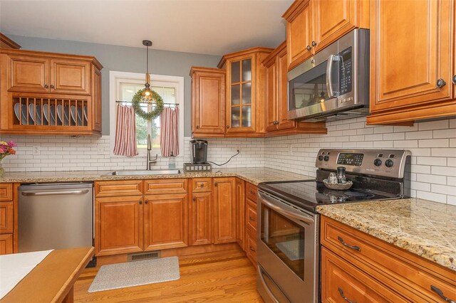 412 Singleton Rd, Anderson, SC 29625 - kitchen with stainless steel appliances, brown cabinetry, and tasteful backsplash