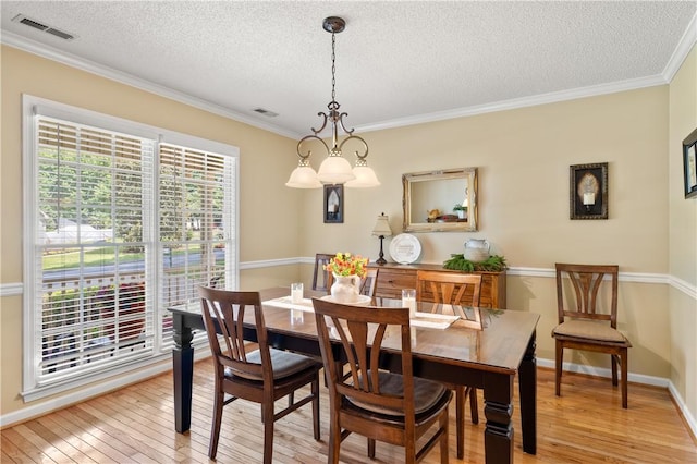 15067 Beacon Ridge Dr, Seneca, SC 29678 - dining area featuring a textured ceiling, light wood-style flooring, and crown molding