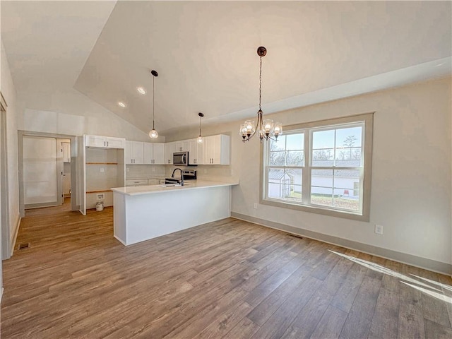 600 S Stribling St, Seneca, SC 29678 - kitchen featuring stainless steel microwave, a peninsula, wood finished floors, a chandelier, and light countertops