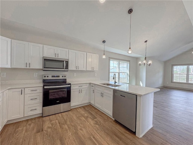 600 S Stribling St, Seneca, SC 29678 - kitchen with stainless steel appliances, vaulted ceiling, light wood-type flooring, white cabinets, and light countertops