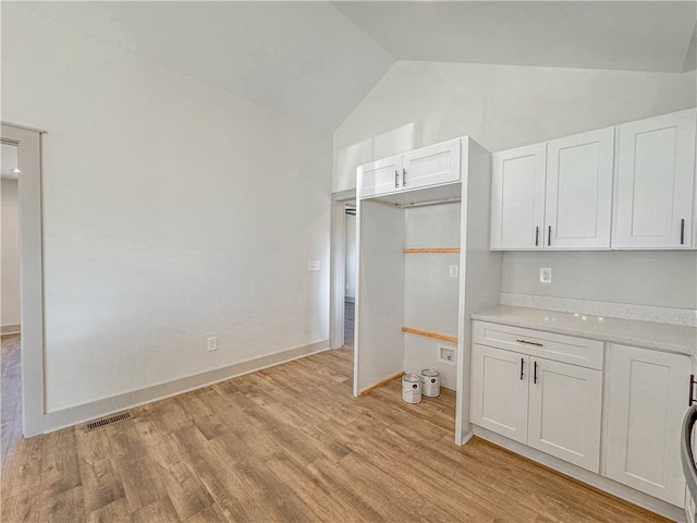 600 S Stribling St, Seneca, SC 29678 - kitchen featuring lofted ceiling, white cabinets, light countertops, and light wood-style flooring