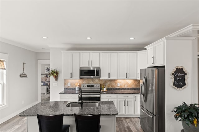 500 Serria Way, Seneca, SC 29678 - kitchen with appliances with stainless steel finishes, dark stone counters, backsplash, light wood-style flooring, and white cabinets