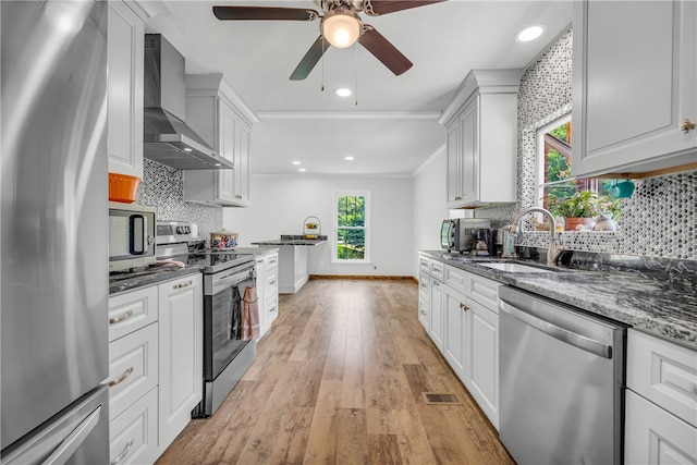 1399 Lake Jemiki Rd, Walhalla, SC 29691 - kitchen featuring stainless steel appliances, wall chimney range hood, ceiling fan, light wood finished floors, and dark stone countertops