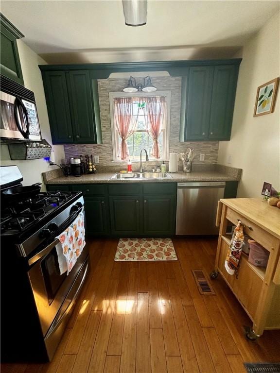 1430 W Main St, West Union, SC 29696 - kitchen featuring appliances with stainless steel finishes, tasteful backsplash, dark wood-style floors, light countertops, and green cabinetry