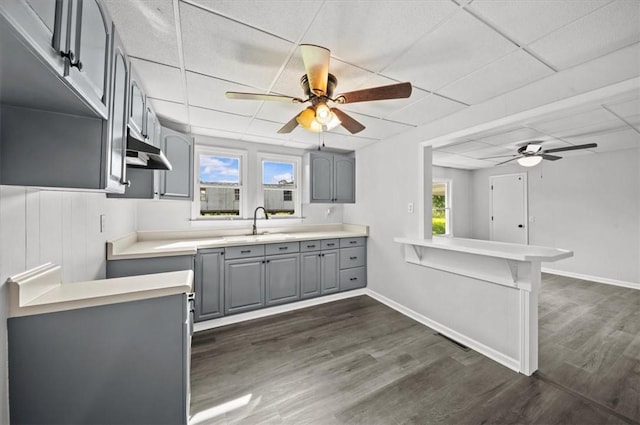 2110 Walhalla Hwy, Pickens, SC 29671 - kitchen with gray cabinetry, ceiling fan, under cabinet range hood, dark wood-style floors, and a drop ceiling