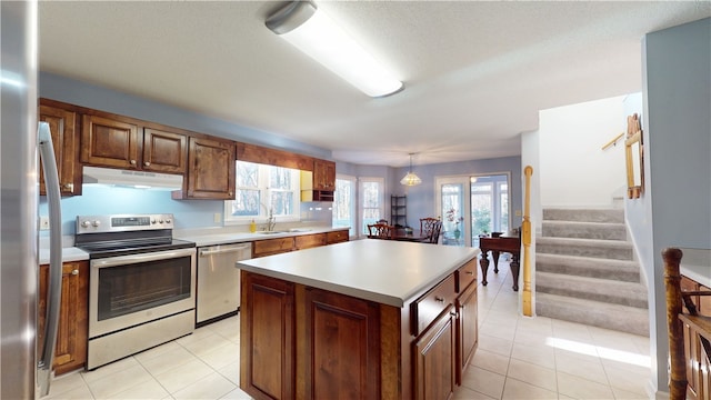 210 Wakefield Dr, Seneca, SC 29678 - kitchen with appliances with stainless steel finishes, under cabinet range hood, light countertops, a kitchen island, and light tile patterned floors