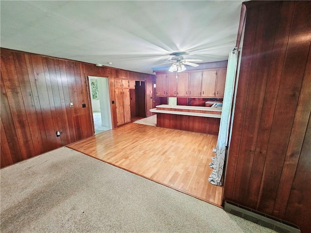 150 Prater Dr, Seneca, SC 29678 - kitchen featuring a baseboard radiator, carpet floors, ceiling fan, wood walls, and light countertops