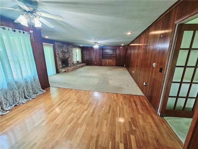 150 Prater Dr, Seneca, SC 29678 - unfurnished living room with a ceiling fan, wood walls, a fireplace, and light wood-style floors