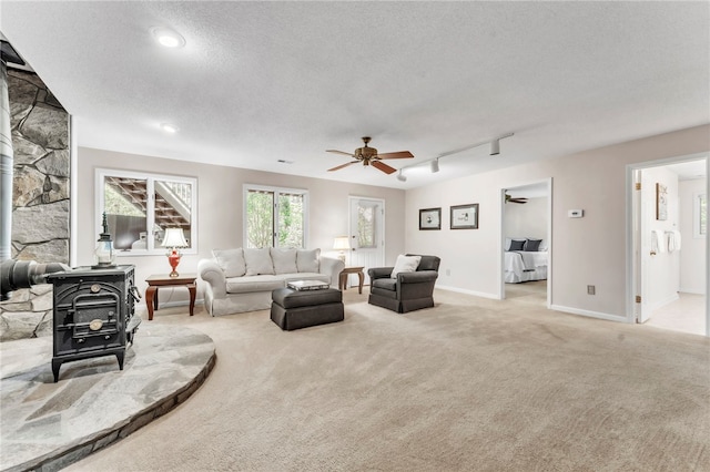 4 Slack Tide Ct, Salem, SC 29676 - living area featuring a wood stove, light colored carpet, a ceiling fan, a textured ceiling, and rail lighting