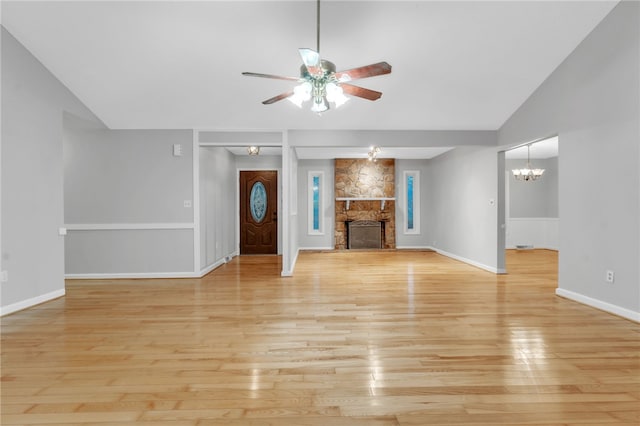 4214 Hembree Creek Rd, Anderson, SC 29625 - unfurnished living room featuring a ceiling fan, light wood finished floors, a stone fireplace, a chandelier, and vaulted ceiling