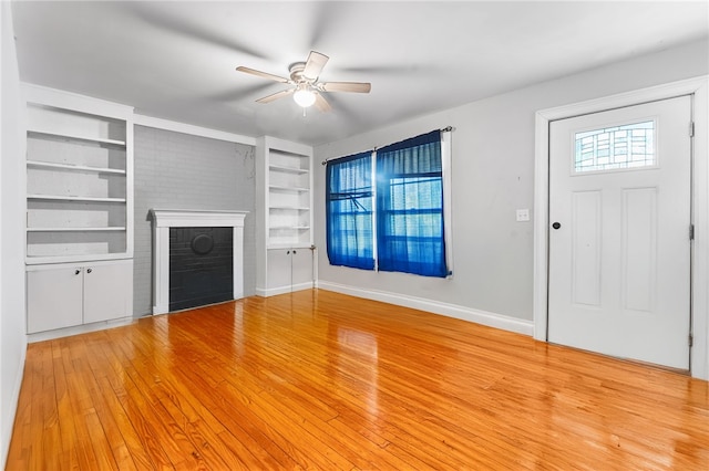 805 Cooley Bridge Rd, Pelzer, SC 29669 - unfurnished living room featuring ceiling fan, built in shelves, a brick fireplace, and wood finished floors