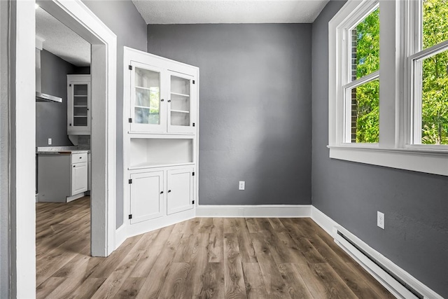 104 W Franklin St, Anderson, SC 29624 - unfurnished room with a baseboard heating unit and wood finished floors
