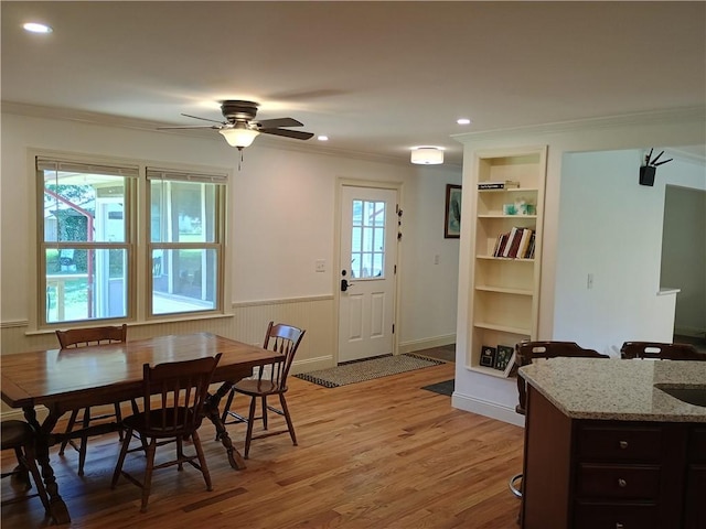 412 Bishop Branch Rd, Pendleton, SC 29670 - dining room with crown molding, light wood-style flooring, a wainscoted wall, a ceiling fan, and built in shelves