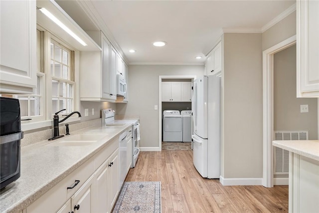 122 Downs Blvd, Clemson, SC 29631 - kitchen featuring washer and clothes dryer, white appliances, white cabinetry, light wood finished floors, and ornamental molding