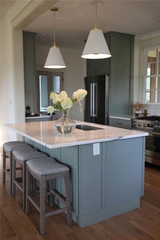 104 E S 5th St, Seneca, SC 29678 - kitchen with appliances with stainless steel finishes, wood finished floors, pendant lighting, ornamental molding, and a kitchen island with sink