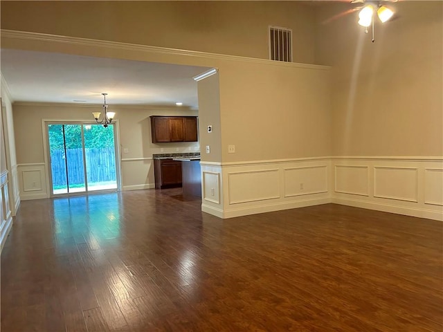 1016 Sand Palm Way, Anderson, SC 29621 - spare room featuring a chandelier, a decorative wall, ornamental molding, dark wood-style flooring, and wainscoting