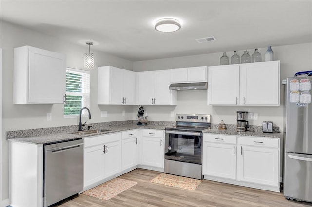 117 Enchanted Walk, Pickens, SC 29671 - kitchen featuring stainless steel appliances, under cabinet range hood, white cabinetry, light wood finished floors, and light stone countertops