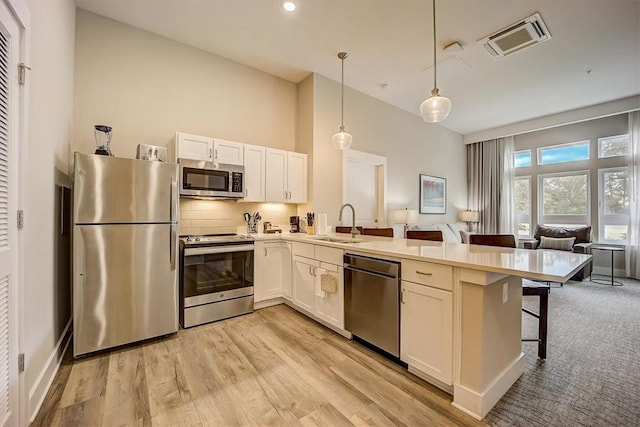 13500 Clemson Blvd Unit 3104Ab, Seneca, SC 29678 - kitchen featuring stainless steel appliances, a peninsula, white cabinetry, a breakfast bar, and light countertops