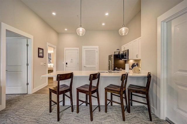 13500 Clemson Blvd Unit 3104Ab, Seneca, SC 29678 - kitchen with stainless steel appliances, a peninsula, a kitchen breakfast bar, light countertops, and white cabinetry