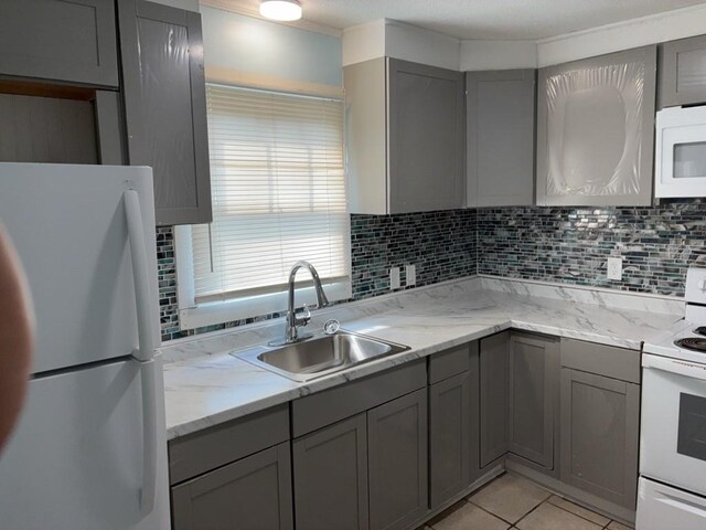 715 Delia St, Anderson, SC 29624 - kitchen with white appliances, gray cabinets, backsplash, and light tile patterned floors