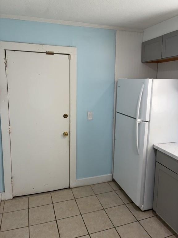 715 Delia St, Anderson, SC 29624 - kitchen with freestanding refrigerator, gray cabinets, light tile patterned floors, light countertops, and ornamental molding