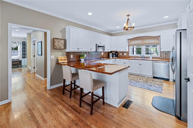 308 Amethyst Way, Seneca, SC 29672 - kitchen with appliances with stainless steel finishes, a peninsula, a kitchen breakfast bar, white cabinets, and a chandelier