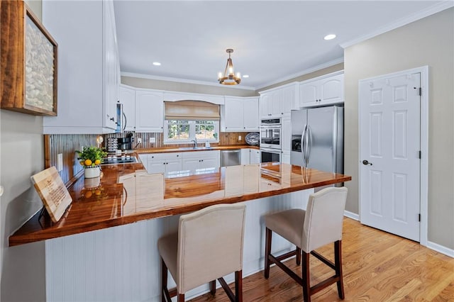 308 Amethyst Way, Seneca, SC 29672 - kitchen with appliances with stainless steel finishes, a peninsula, a chandelier, crown molding, and tasteful backsplash