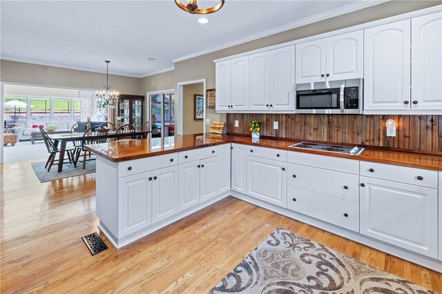 308 Amethyst Way, Seneca, SC 29672 - kitchen featuring stainless steel microwave, a chandelier, cooktop, light wood-style flooring, and a peninsula