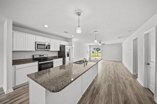 121 Traditions Blvd, Anderson, SC 29625 - kitchen featuring stainless steel appliances, wood finished floors, white cabinets, a large island with sink, and decorative light fixtures