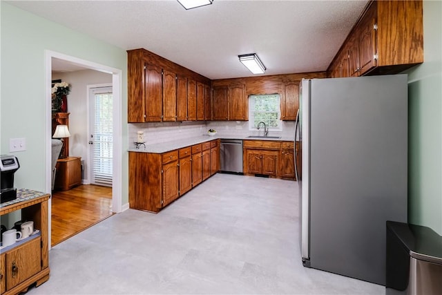 100 Crosscreek Dr, Anderson, SC 29621 - kitchen featuring appliances with stainless steel finishes, brown cabinetry, light countertops, and decorative backsplash