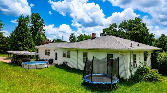 7703 Moorefield Memorial Hwy, Liberty, SC 29657 - rear view of house featuring a trampoline, a chimney, and a lawn