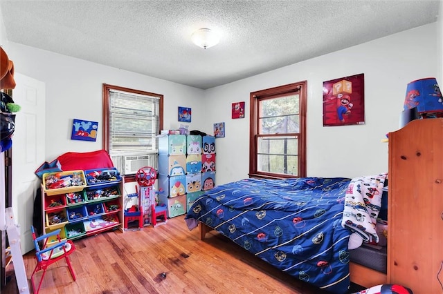 7703 Moorefield Memorial Hwy, Liberty, SC 29657 - bedroom featuring multiple windows, wood finished floors, cooling unit, and a textured ceiling