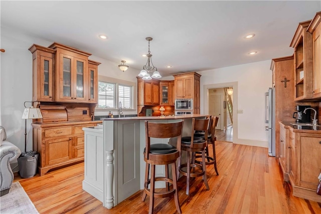 251 W Mcelhaney Rd, Taylors, SC 29687 - kitchen with built in microwave, brown cabinets, high end refrigerator, a kitchen island, and light wood-style floors