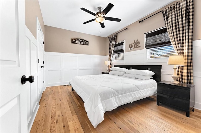 1047 Tranquility Ln, Hartwell, GA 30643 - bedroom featuring a decorative wall, hardwood / wood-style floors, wainscoting, and ceiling fan