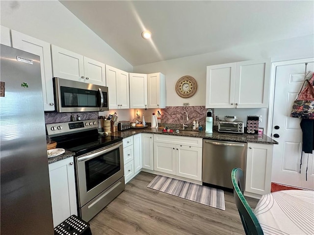 118 Branch St, Walhalla, SC 29691 - kitchen with appliances with stainless steel finishes, lofted ceiling, white cabinets, and decorative backsplash